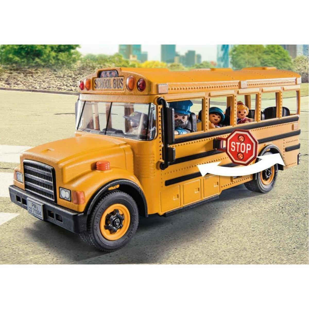 Un autobús escolar de juguete amarillo con figuras y señal de stop abatible sobre fondo urbano.