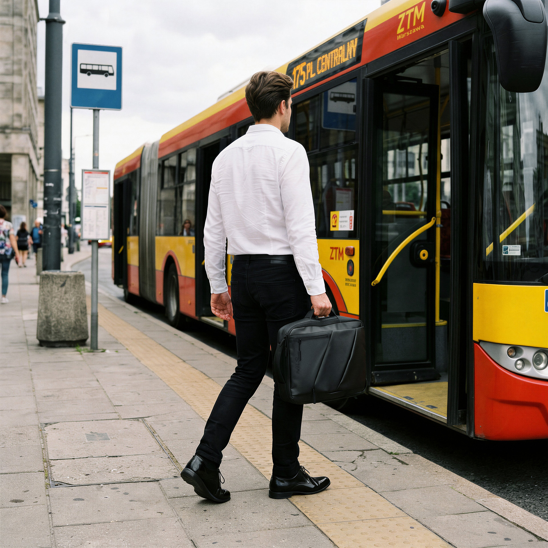 Mężczyzna w białej koszuli z czarną teczką wsiada do autobusu na przystanku.