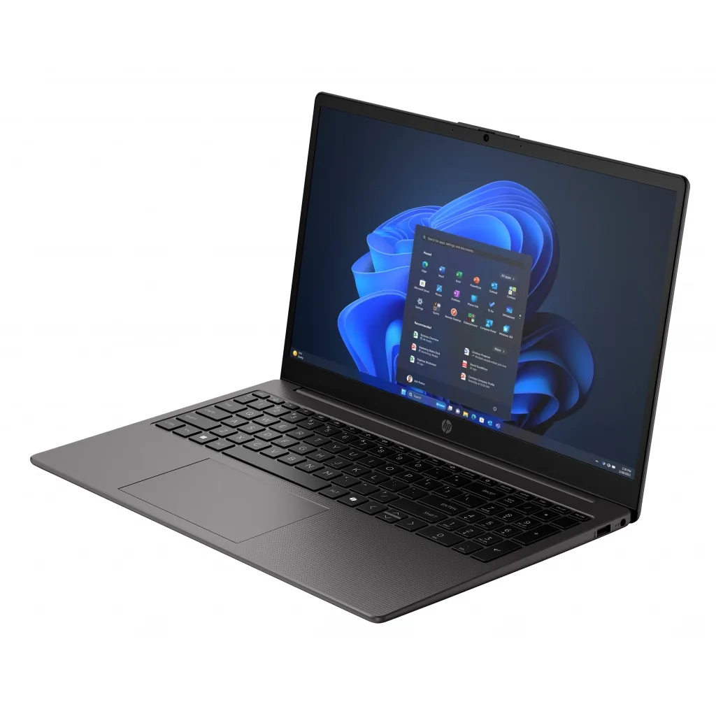 Açık ekranlı ve mavimsi Windows duvar kağıtlı gri bir dizüstü bilgisayar beyaz bir yüzey üzerinde duruyor.