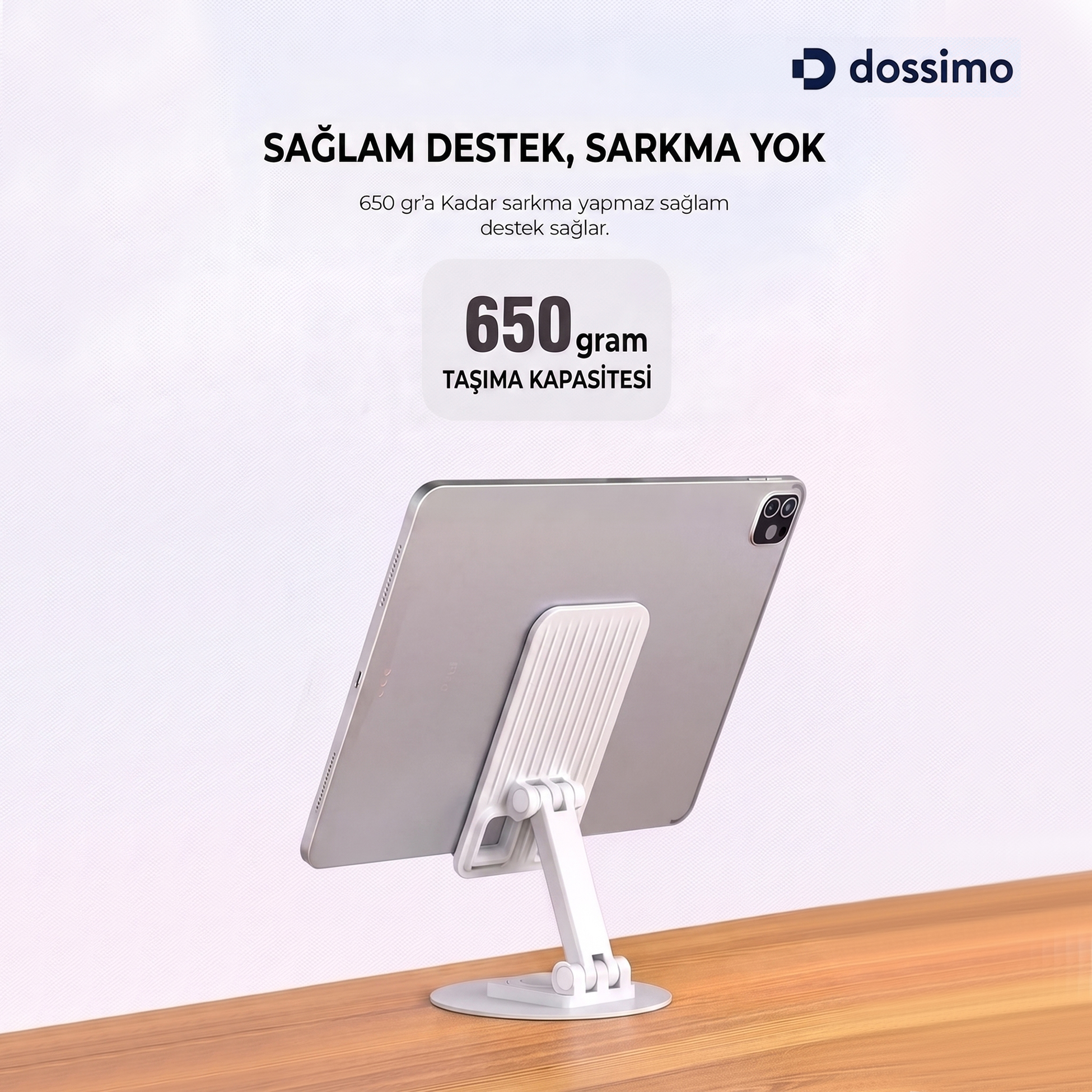 Ahşap masa üzerinde beyaz stantta duran gri bir tablet ve üstte tanıtım yazısı.