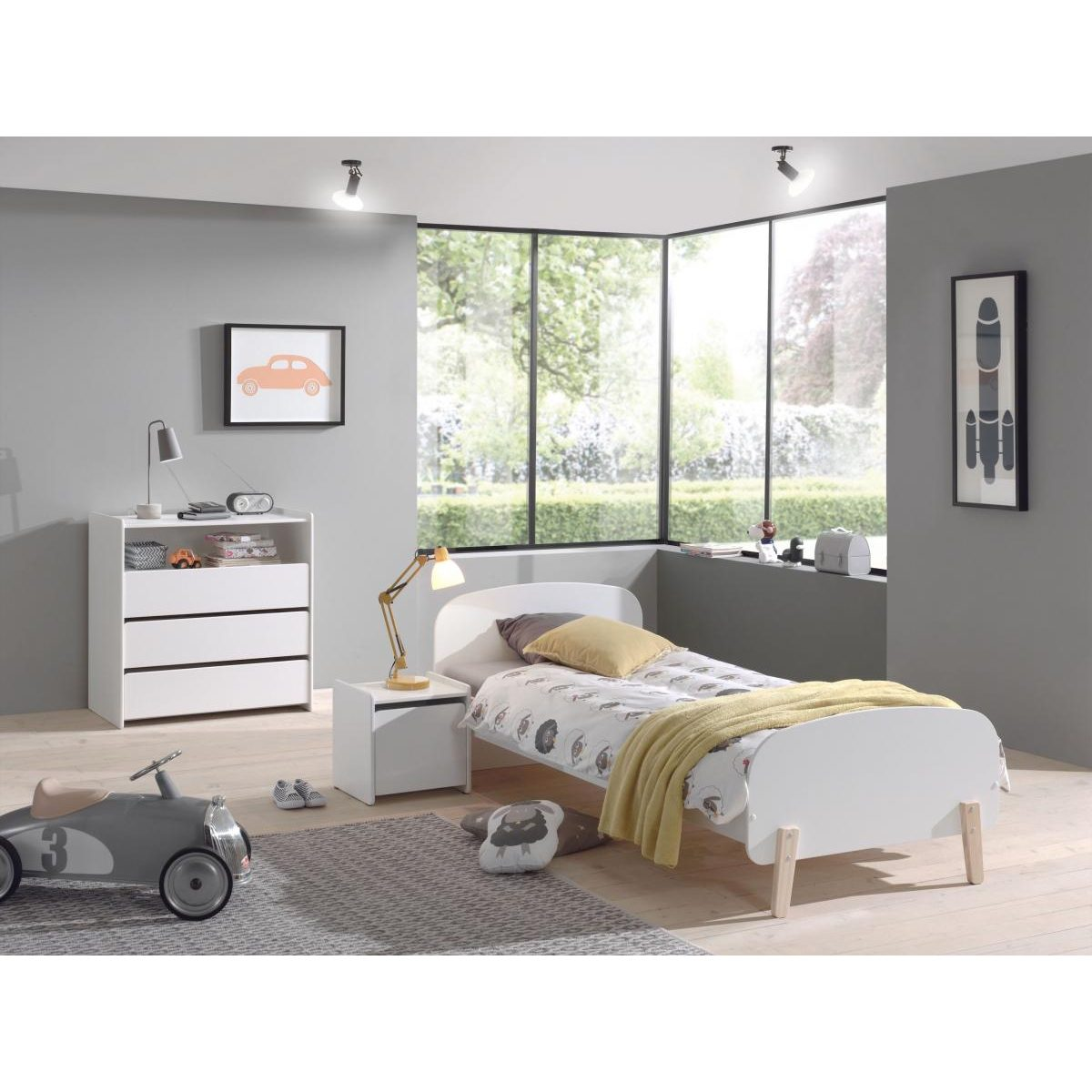 Moderne Kinderzimmer mit weißem Bett, Nachttischlampe, Kommode und einem grauen Spielzeugauto.
