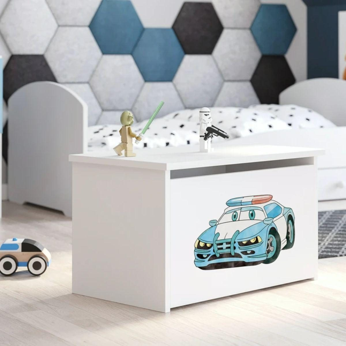 Eine weiße Spielzeugkiste mit Polizeiauto-Aufdruck steht in einem Kinderzimmer, darauf stehen kleine Figuren.