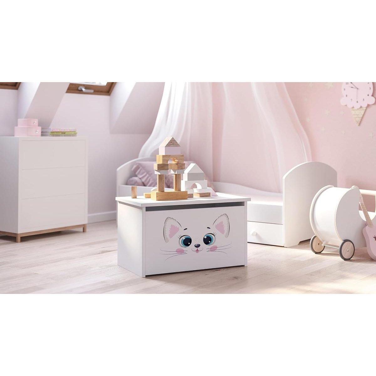 Weisse Spielzeugtruhe mit süßem Katzengesicht im hellen Kinderzimmer mit Holzwürfeln darauf.