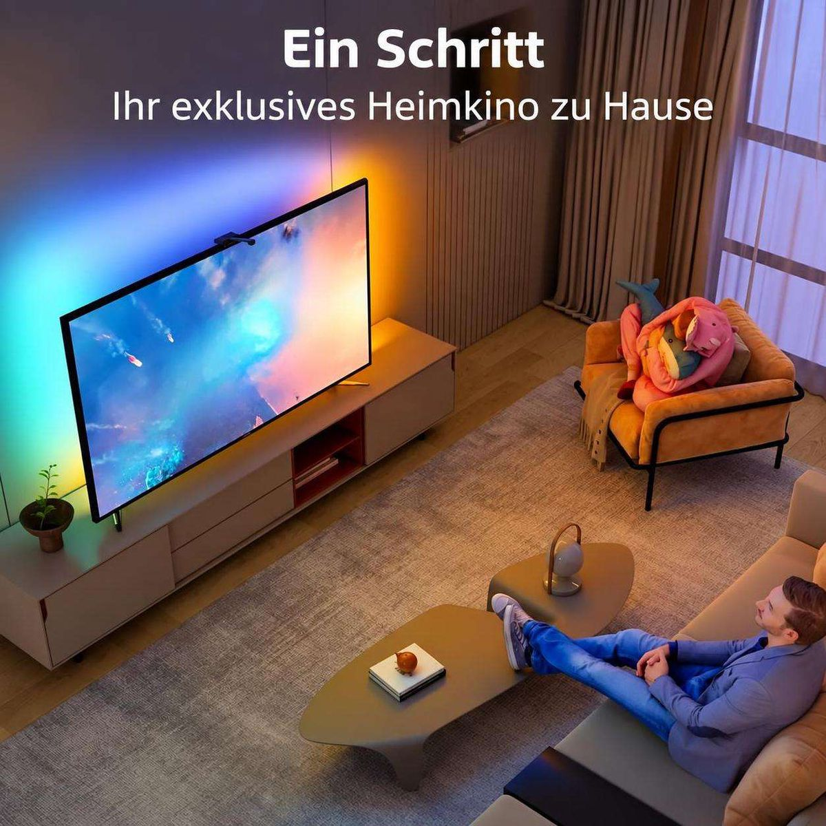 Ein Mann sitzt in einem gemütlichen Wohnzimmer vor einem großen Fernseher mit farbiger Hintergrundbeleuchtung.