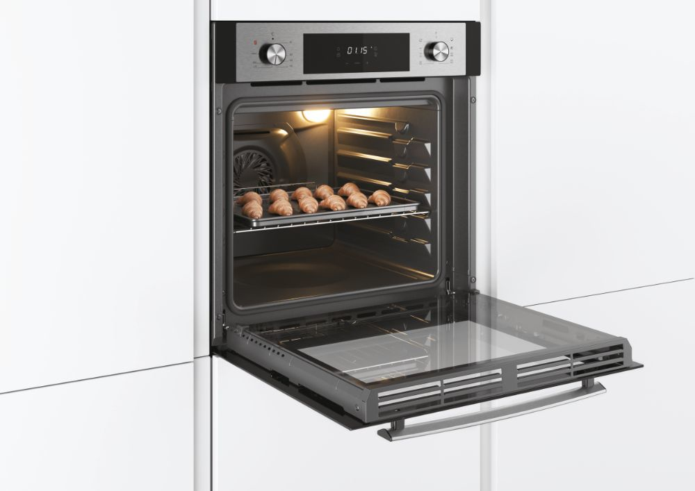 Un forno da incasso aperto con una teglia di piccoli croissant all'interno, in una cucina bianca.