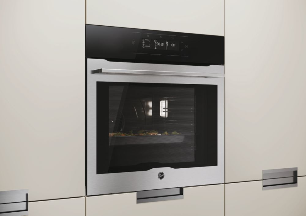 Moderno forno da incasso in acciaio inossidabile con display digitale e finestra in una cucina chiara.