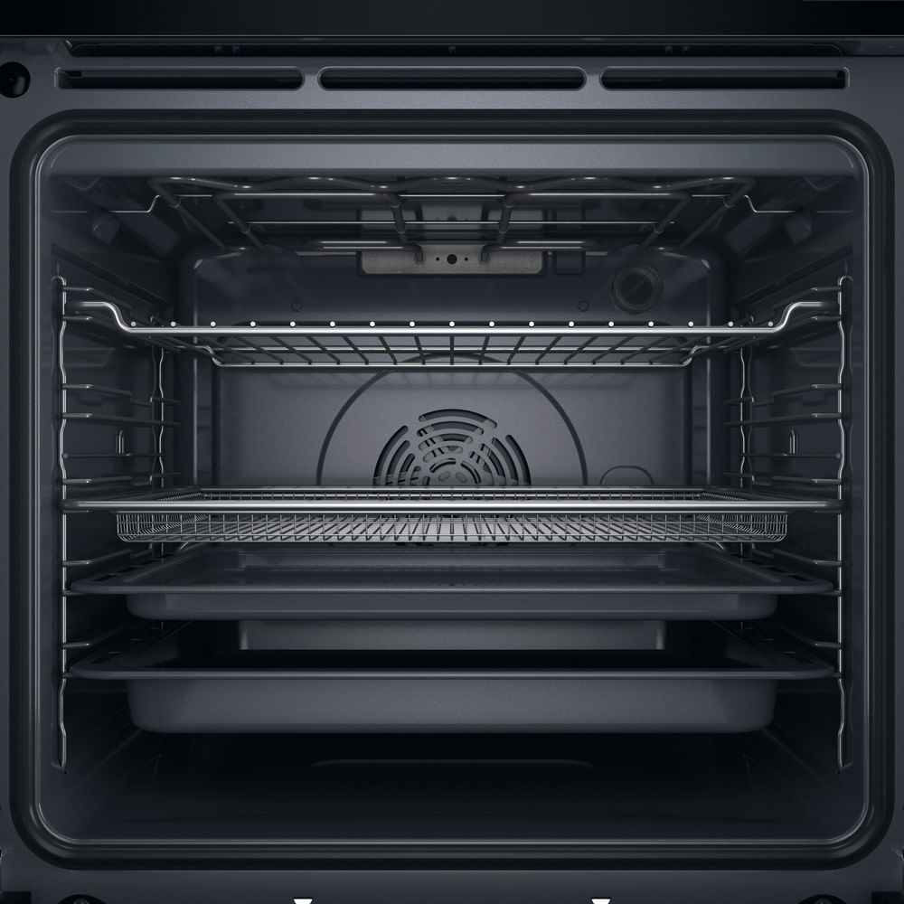 Interno di un forno nero con griglie metalliche, un cestello e due teglie.