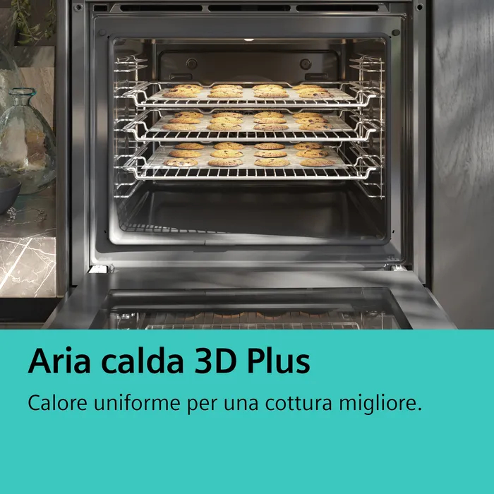 Un forno aperto con tre griglie piene di biscotti su teglie.