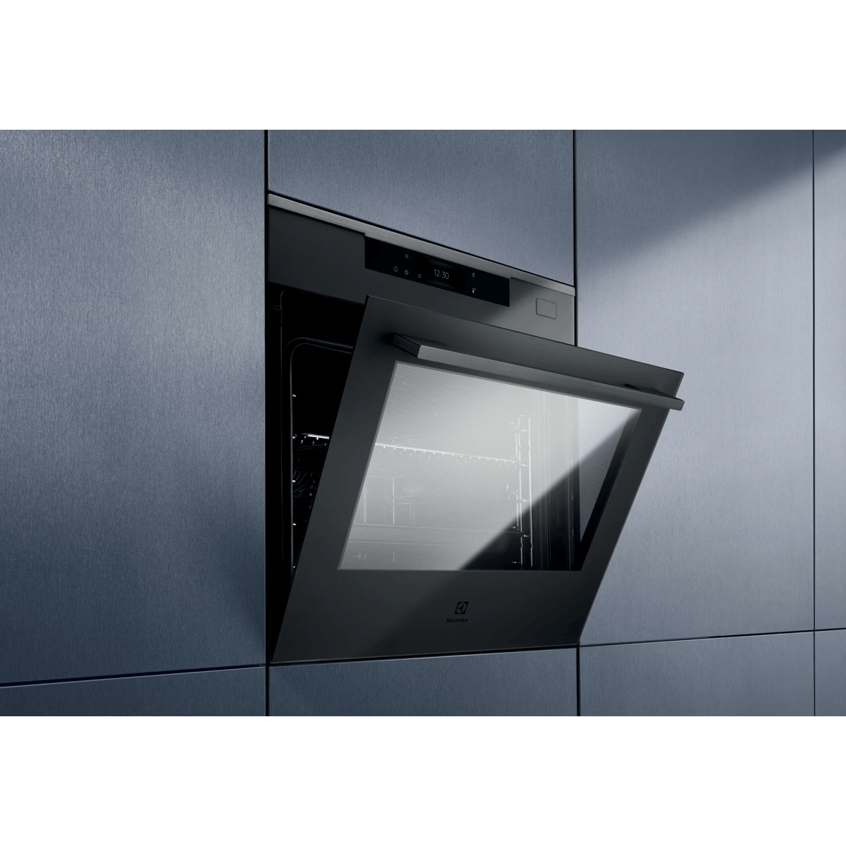 Un moderno forno da incasso nero con porta a vetro leggermente aperta in mobili blu scuro.