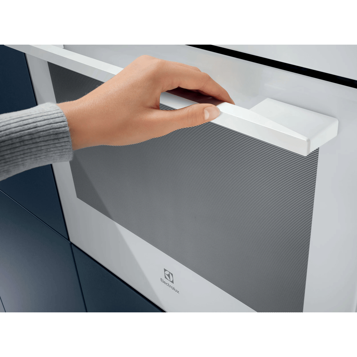 Una mano apre la porta bianca di un forno Electrolux.