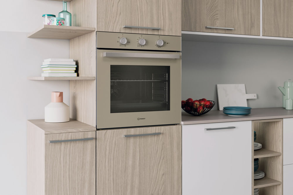 Cucina moderna con forno beige, mobili in legno, cesta di frutta e mensole.