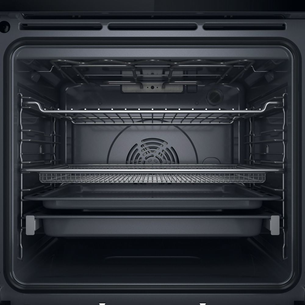 L'interno di un moderno forno scuro con griglie e teglie multiple.