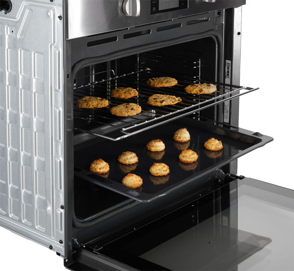 Un forno aperto in acciaio inossidabile con due griglie con biscotti.