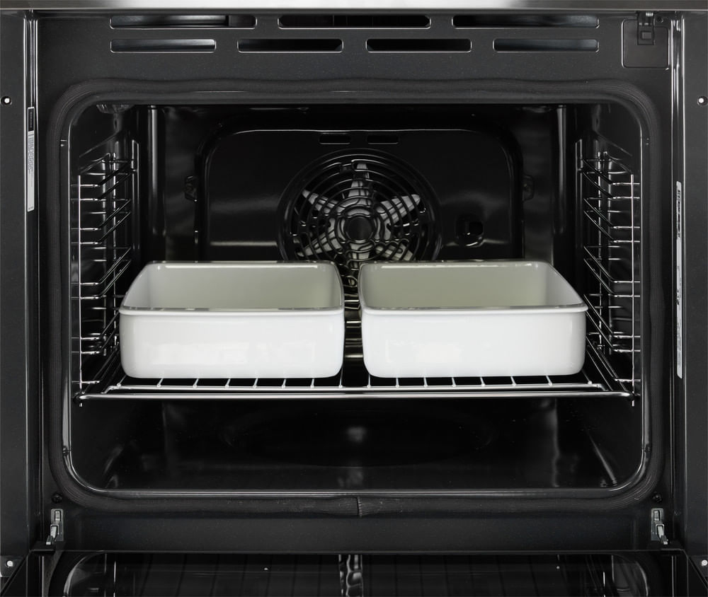 Due teglie bianche su una griglia all'interno di un forno nero.