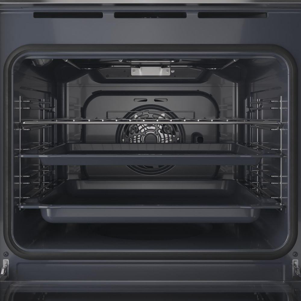 Interno di un forno con due teglie, una griglia e una ventola di convezione sulla parete posteriore.