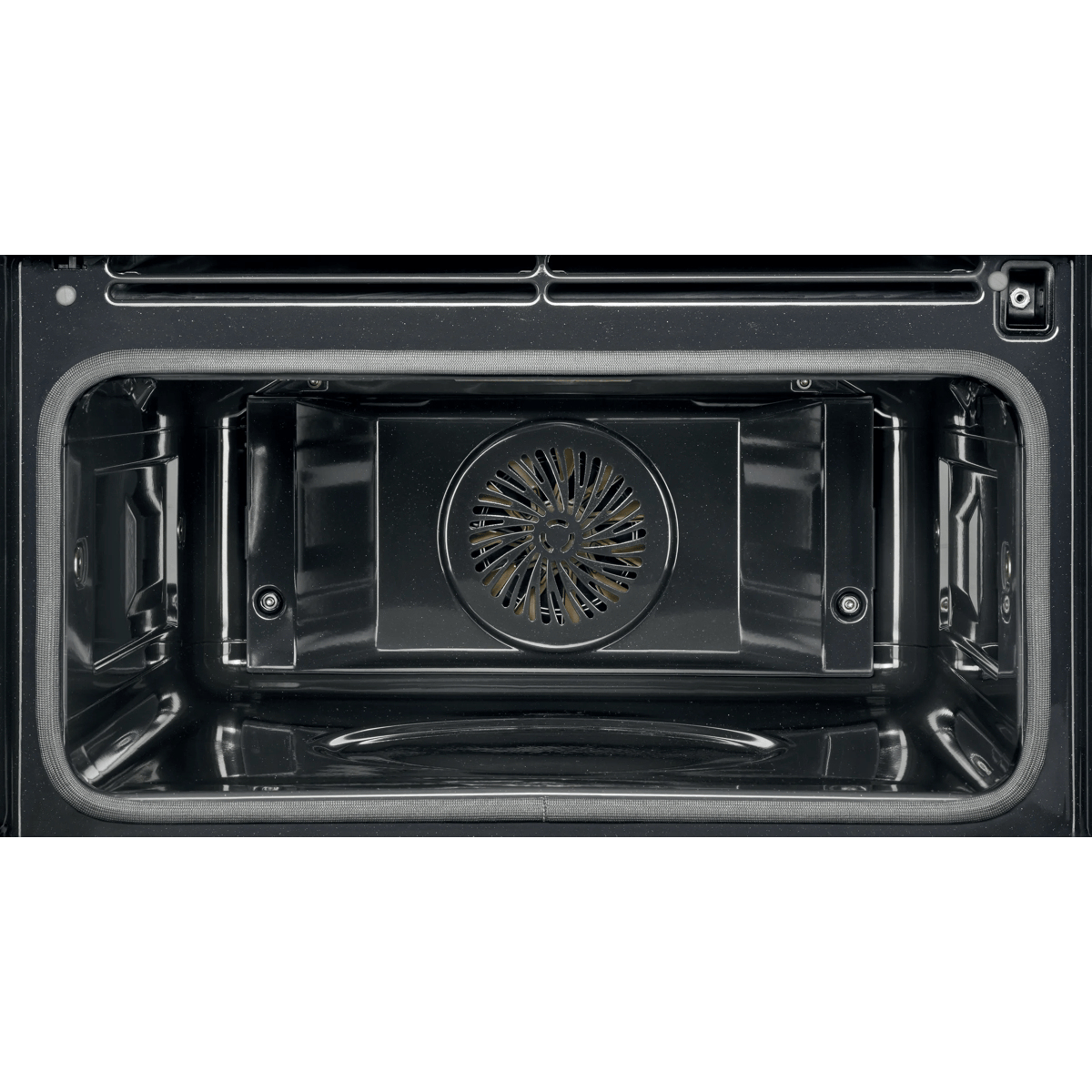 L'interno di un forno nero vuoto con una copertura della ventola a convezione circolare sulla parete posteriore.