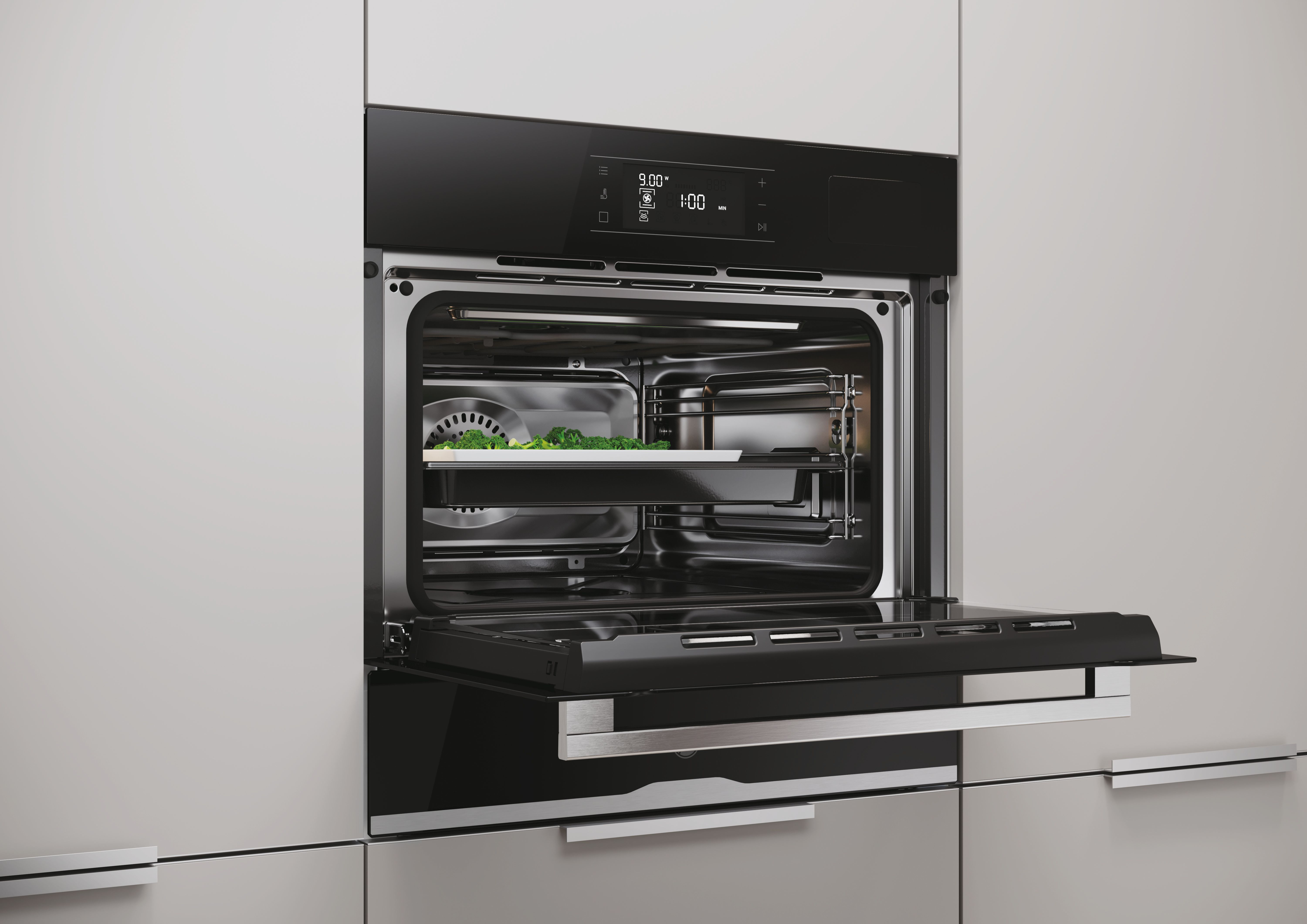 Forno nero a incasso con porta aperta che mostra broccoli su una teglia all'interno.
