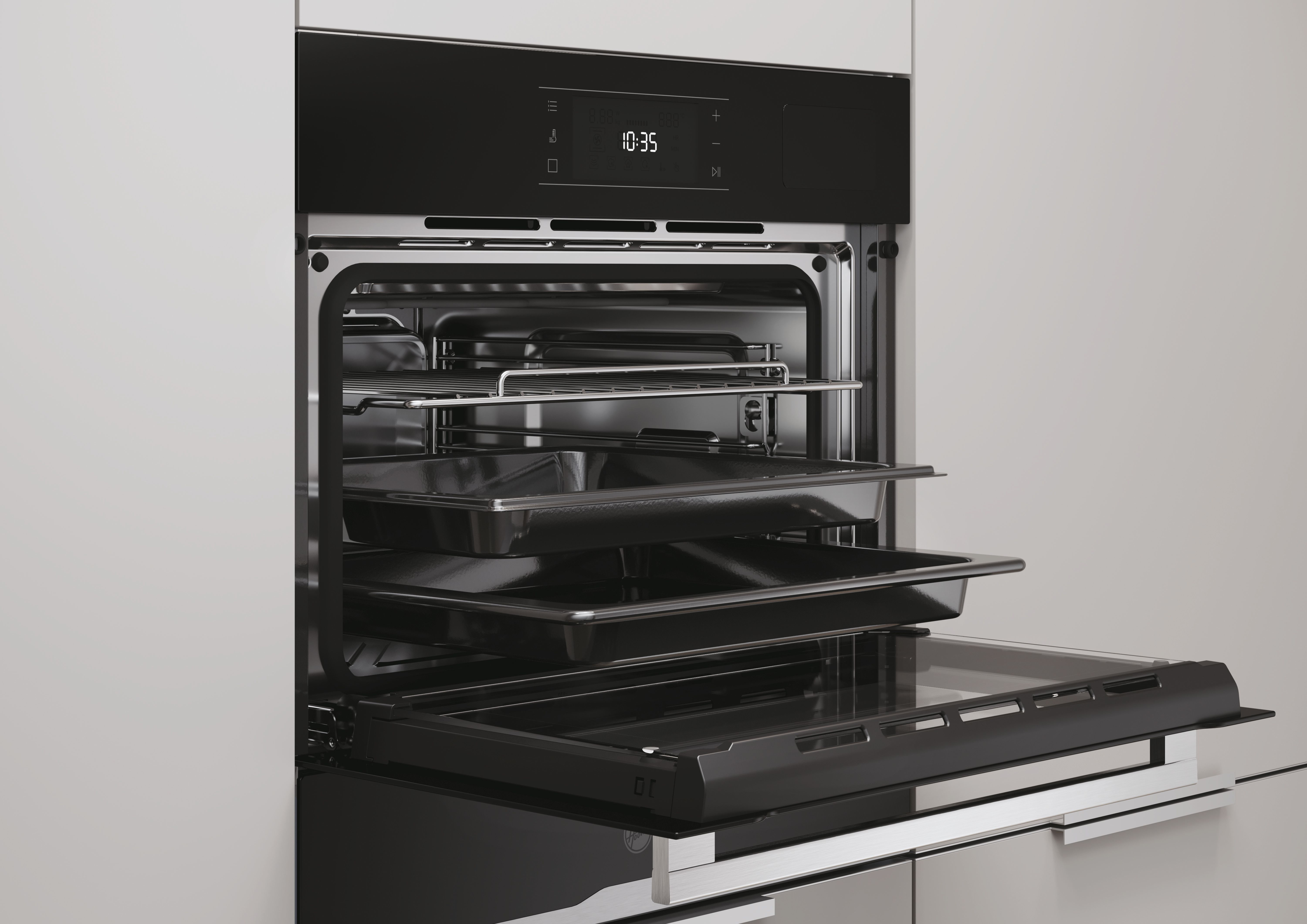 Un moderno forno da incasso nero con la porta aperta, che mostra due teglie e una griglia.