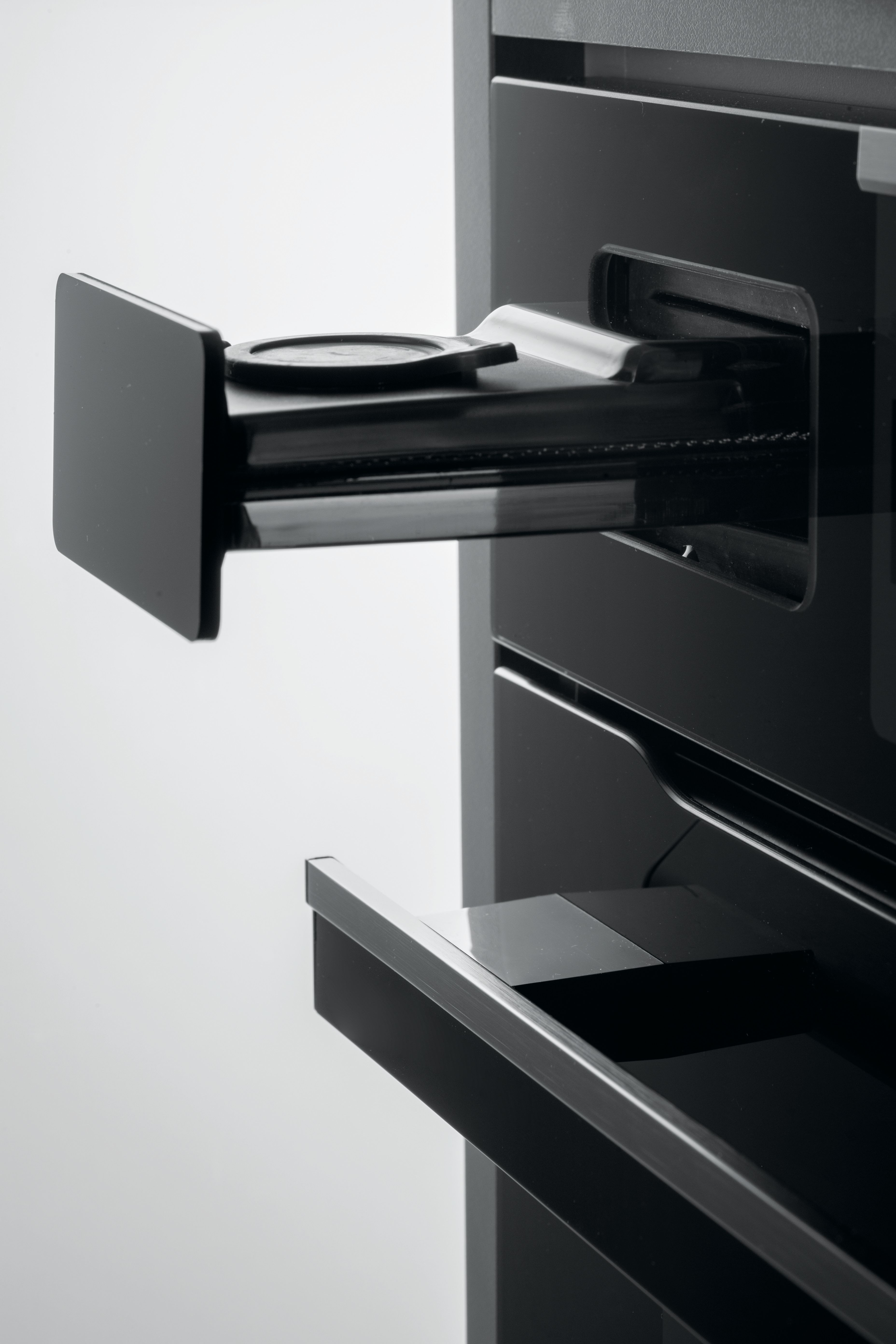 Primo piano di una moderna macchina da caffè nera con due cassetti aperti, dal design elegante.