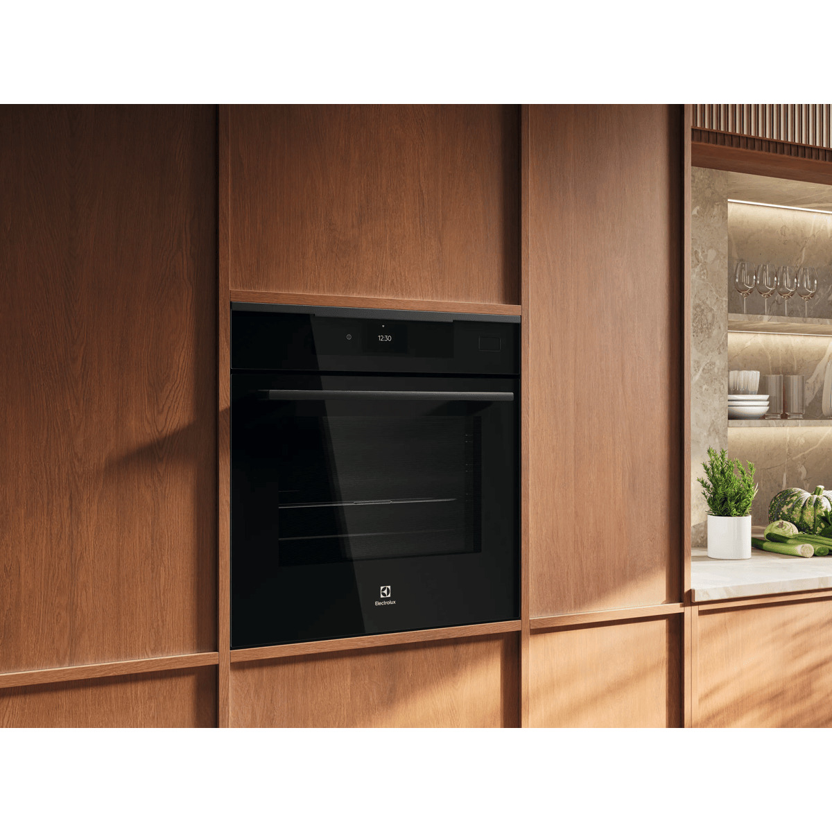 Un moderno forno da incasso nero in mobili da cucina in legno con mensola illuminata, bicchieri e verdure.