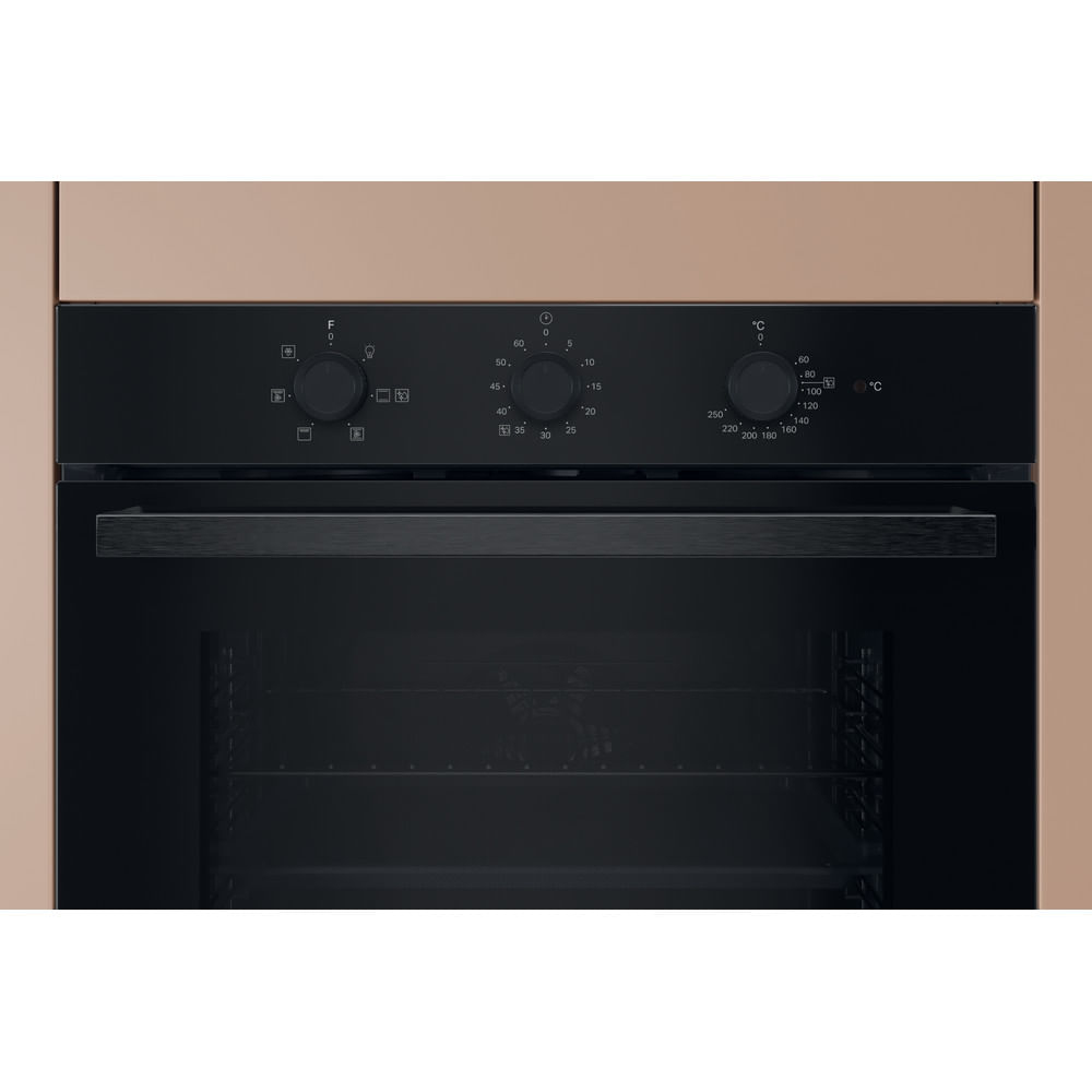 Un forno nero da incasso con tre manopole e maniglia su sfondo beige.
