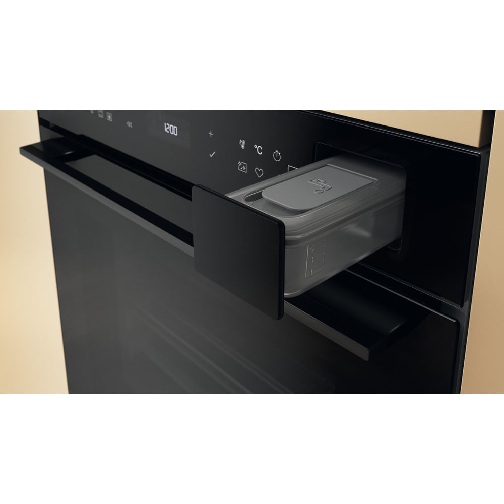 Un forno nero con un serbatoio d'acqua estratto in alto a destra.