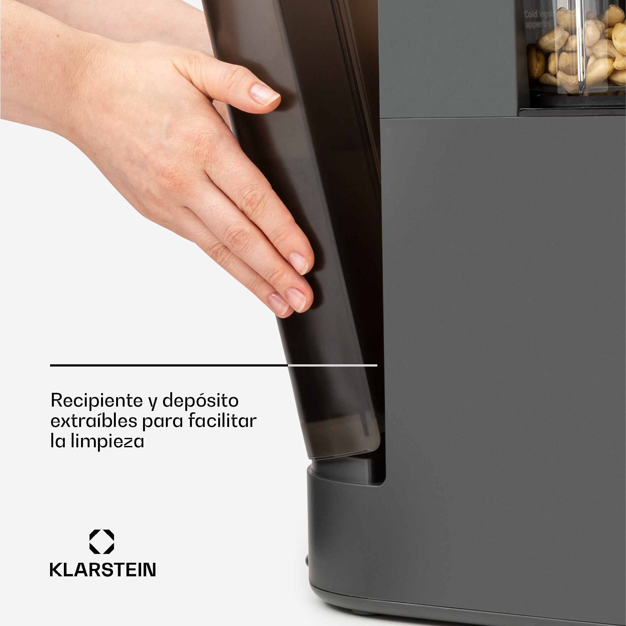 Una mano retira el recipiente extraíble de un electrodoméstico gris.