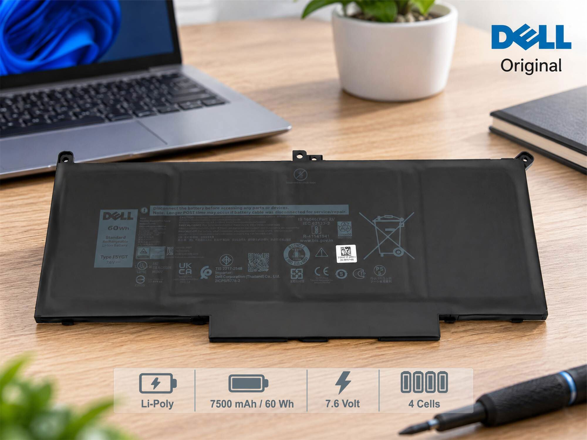 Originaler Dell-Laptop-Akku auf Holztisch mit Laptop im Hintergrund.