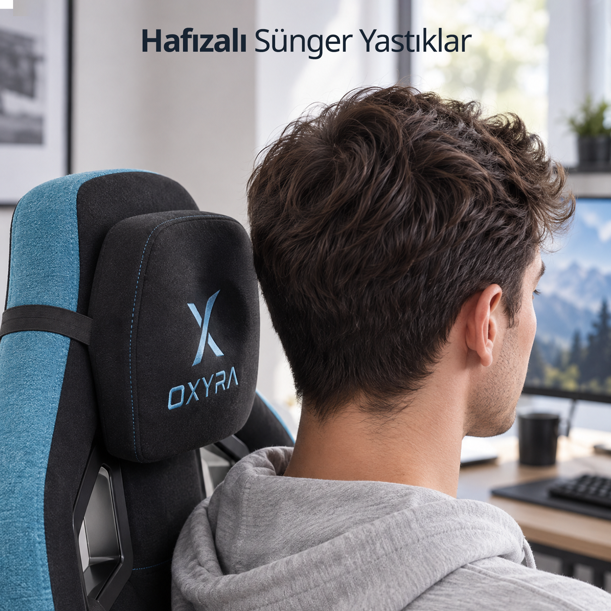 Genç bir adam, bir odada OXYRA baş destekli mavi-siyah oyuncu koltuğunda oturuyor.