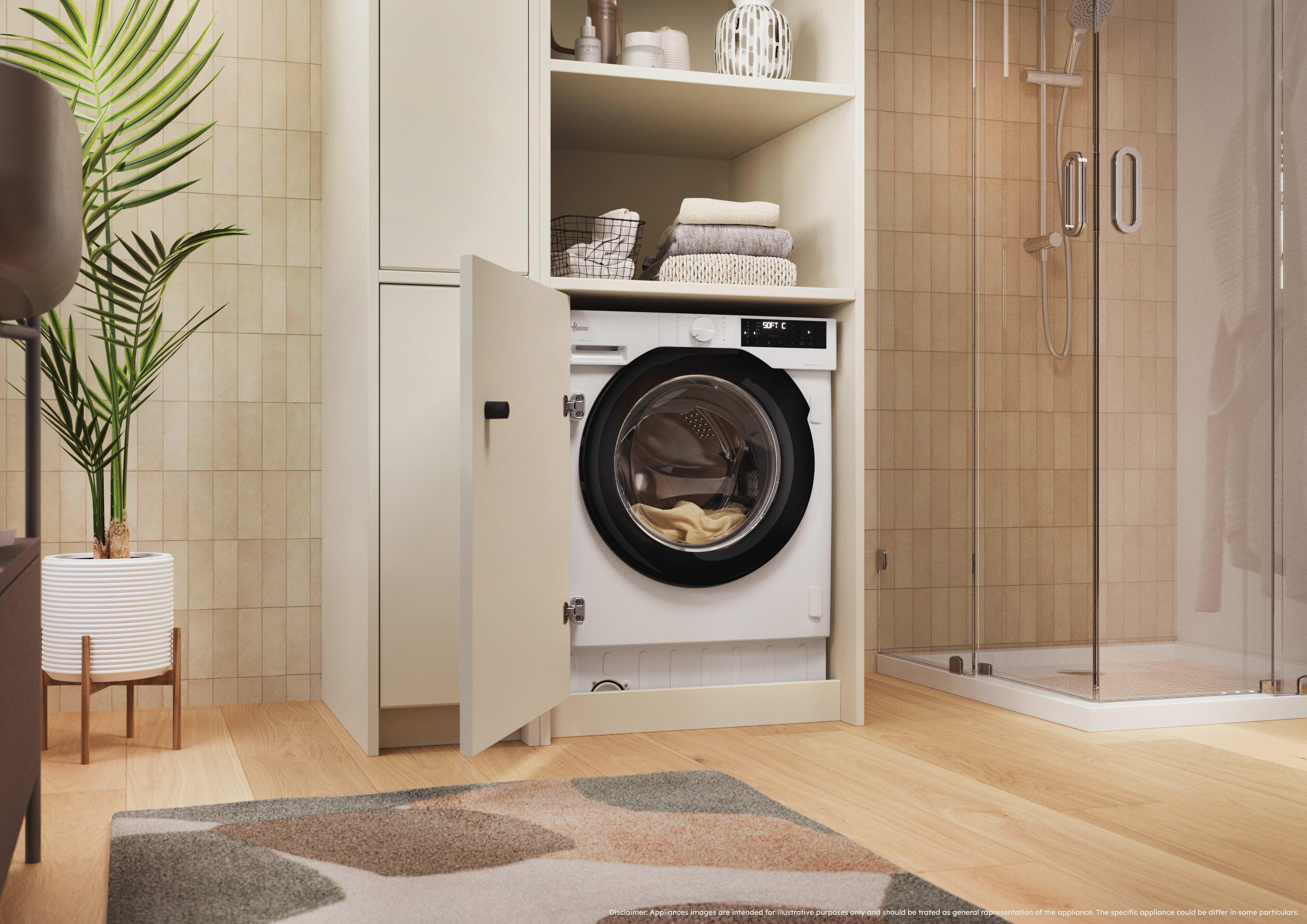 Moderna lavatrice integrata in un mobile da bagno chiaro vicino a una doccia in vetro.
