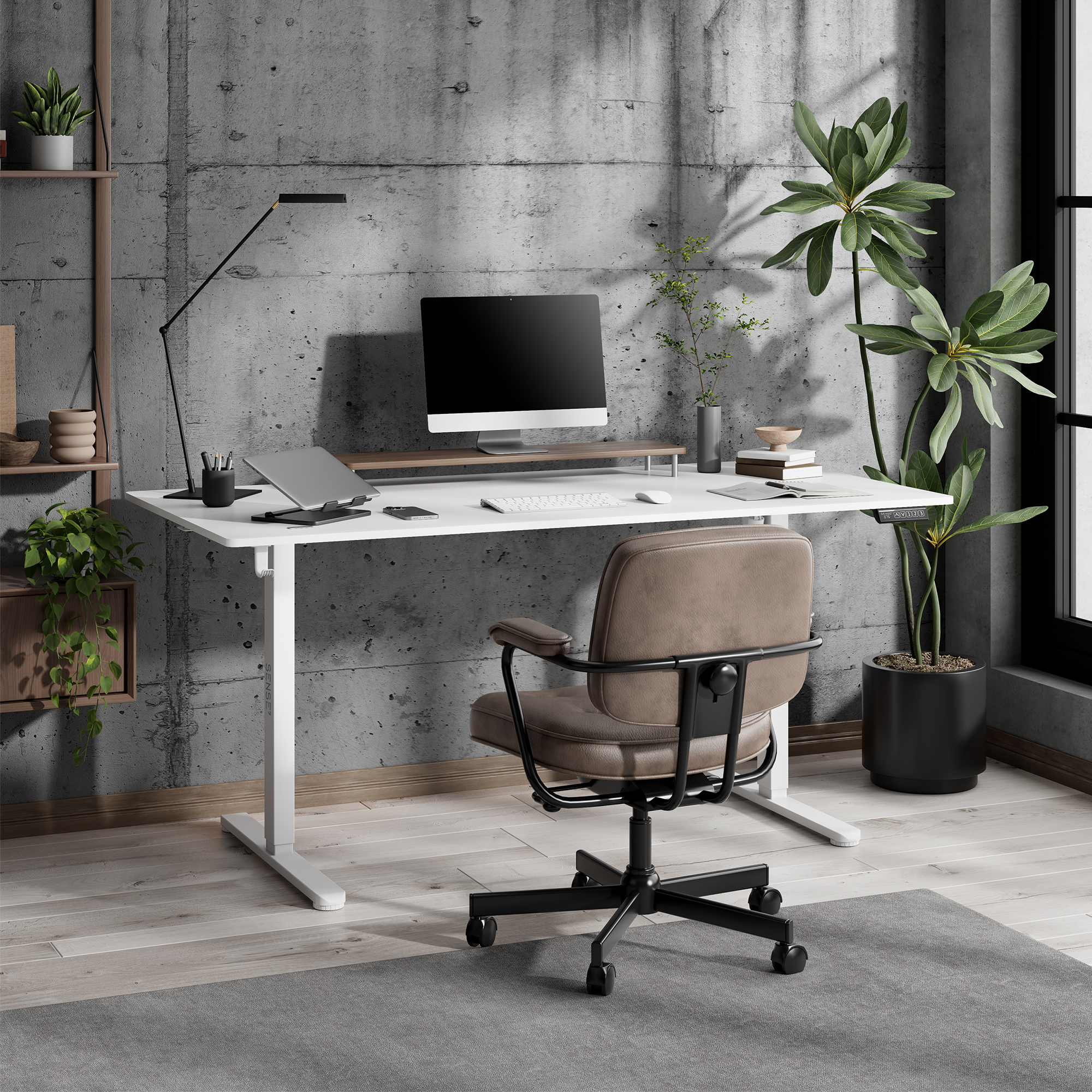 Espacio de trabajo moderno con escritorio blanco, monitor, silla y plantas frente a pared de hormigón.