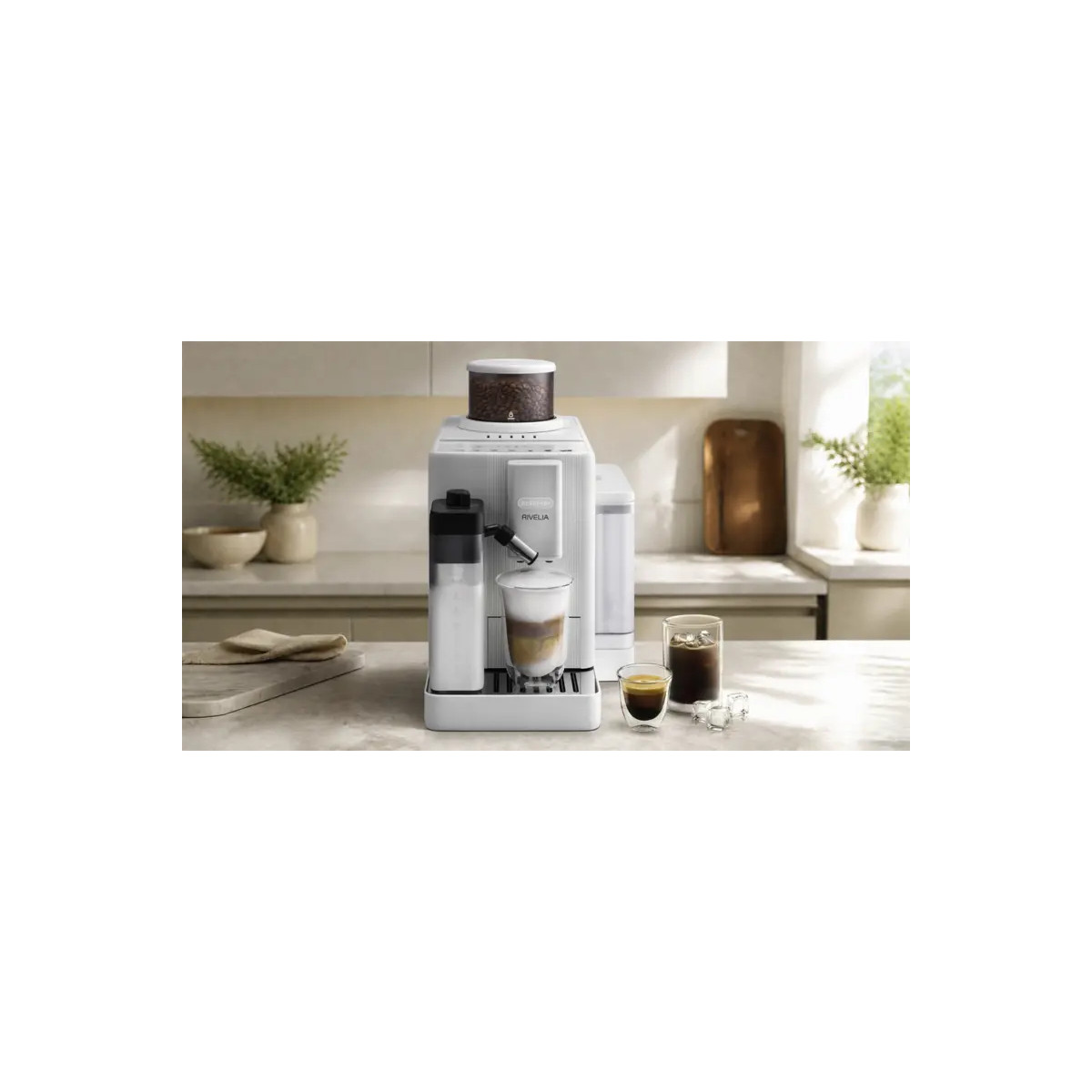 Una cafetera blanca se encuentra en la encimera de la cocina, al lado de vasos con café y hielo.