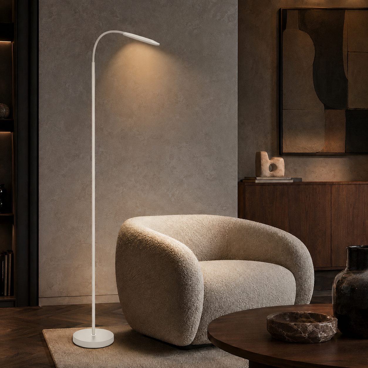 Una lámpara de pie blanca ilumina junto a un sillón claro en una habitación moderna con muebles de madera oscura.