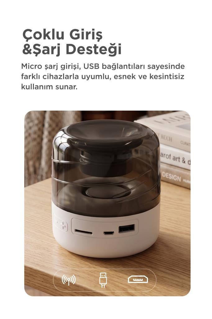 Çoklu şarj portlarına sahip beyaz ve koyu şeffaf kablosuz hoparlör ahşap masada duruyor.
