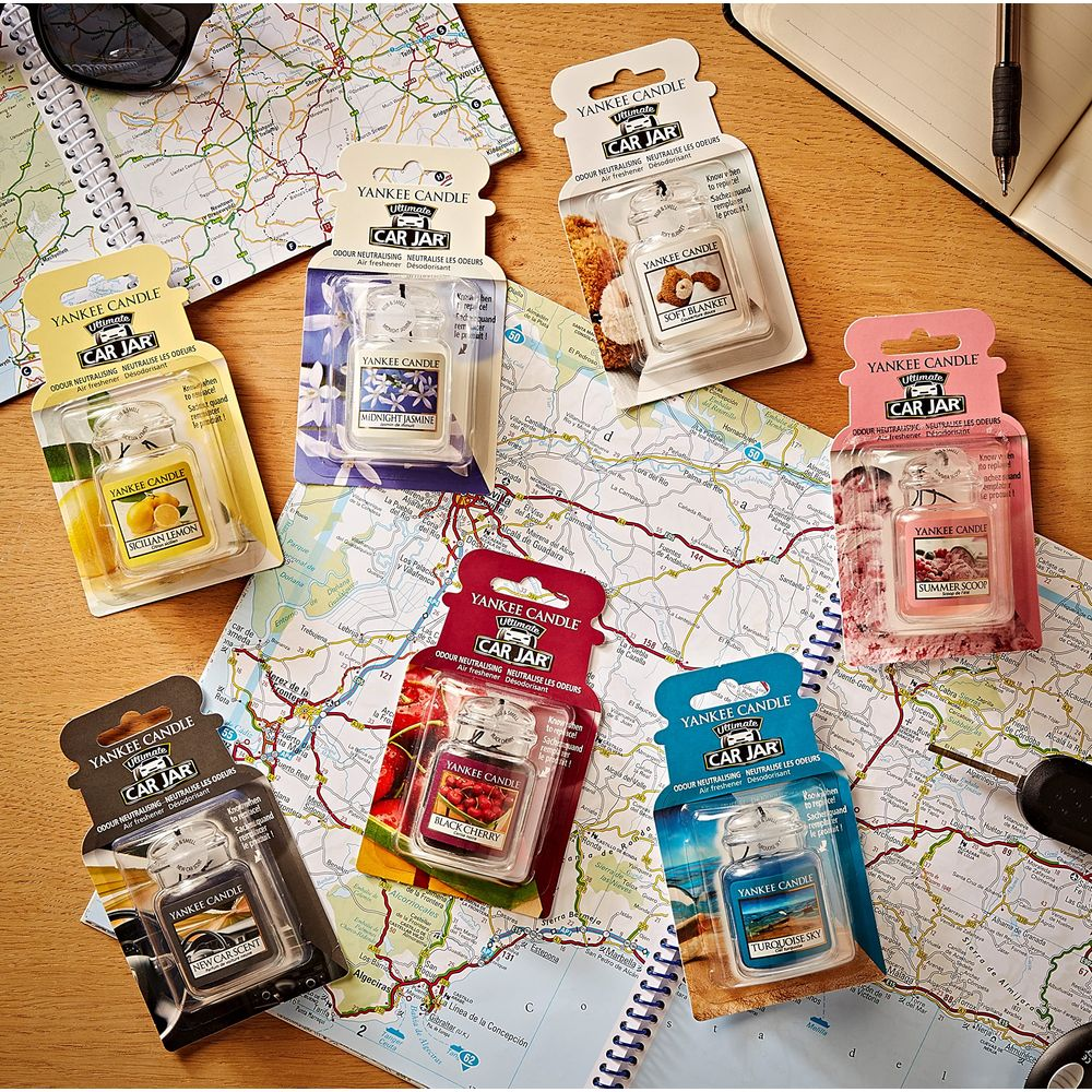Verschiedene Yankee Candle Car Jar Lufterfrischer liegen auf einer Straßenkarte.