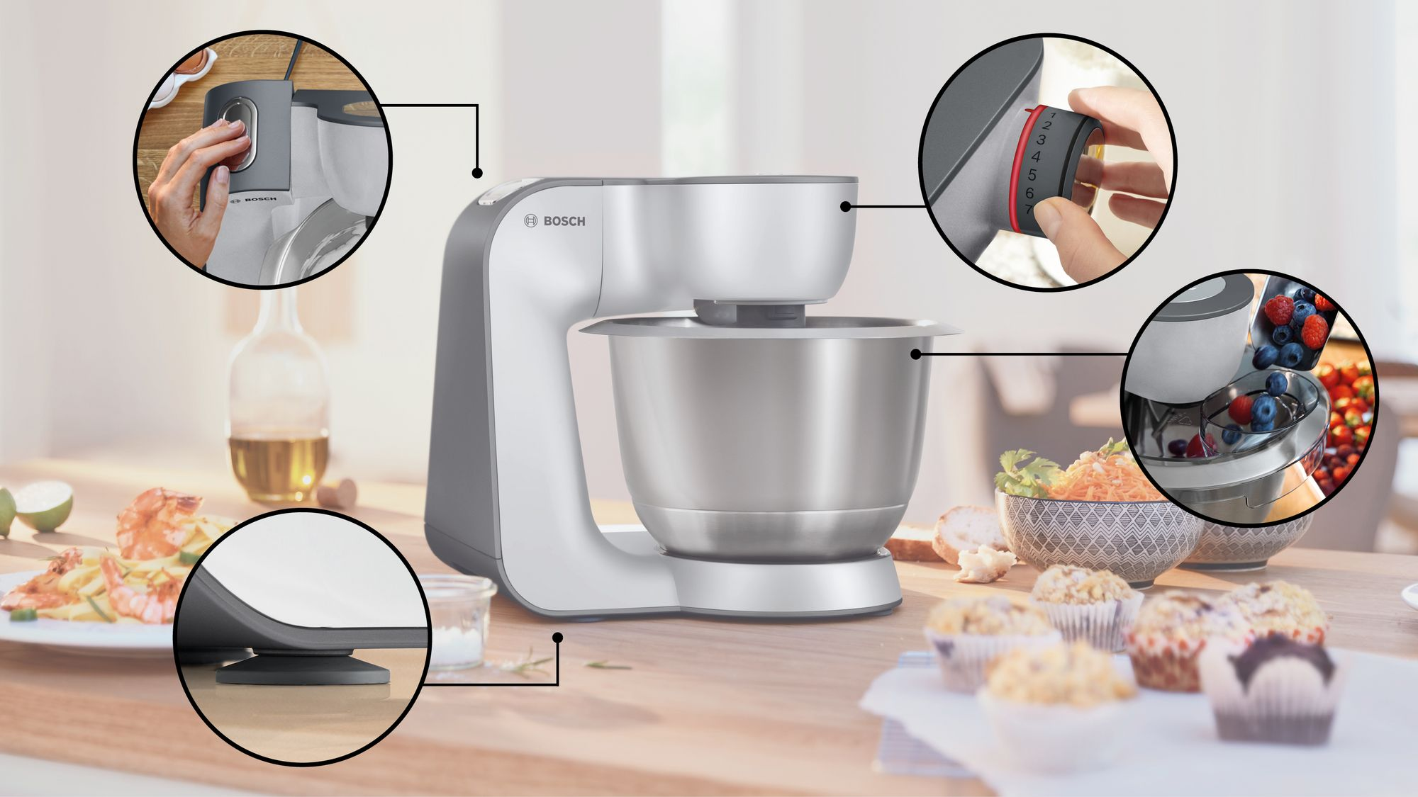 Impastatrice Bosch grigia su un tavolo con cupcake e cibo, con dettagli in primo piano.