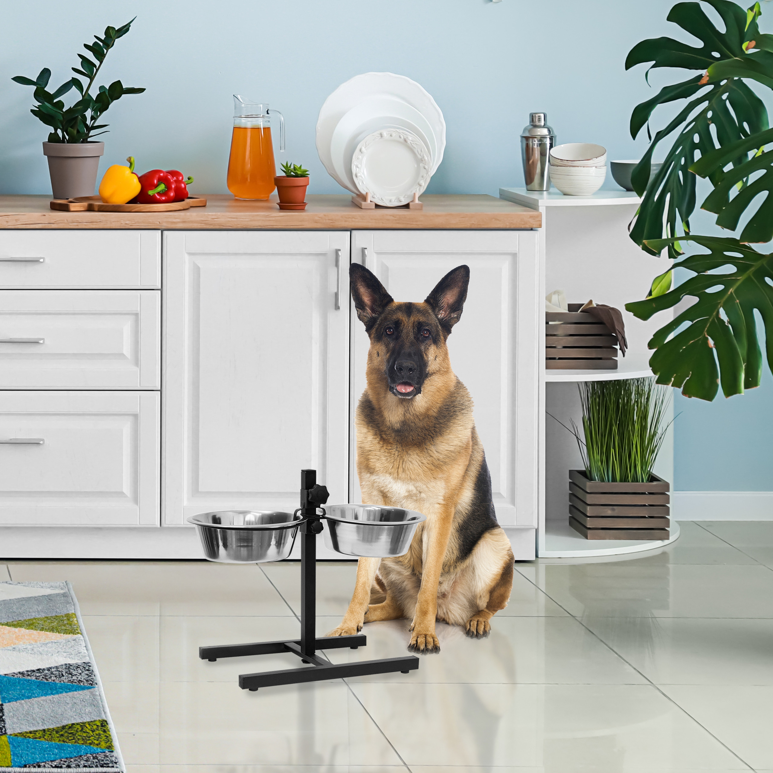 Ein Schäferhund sitzt vor zwei Futternäpfen in einer hellen Küche.