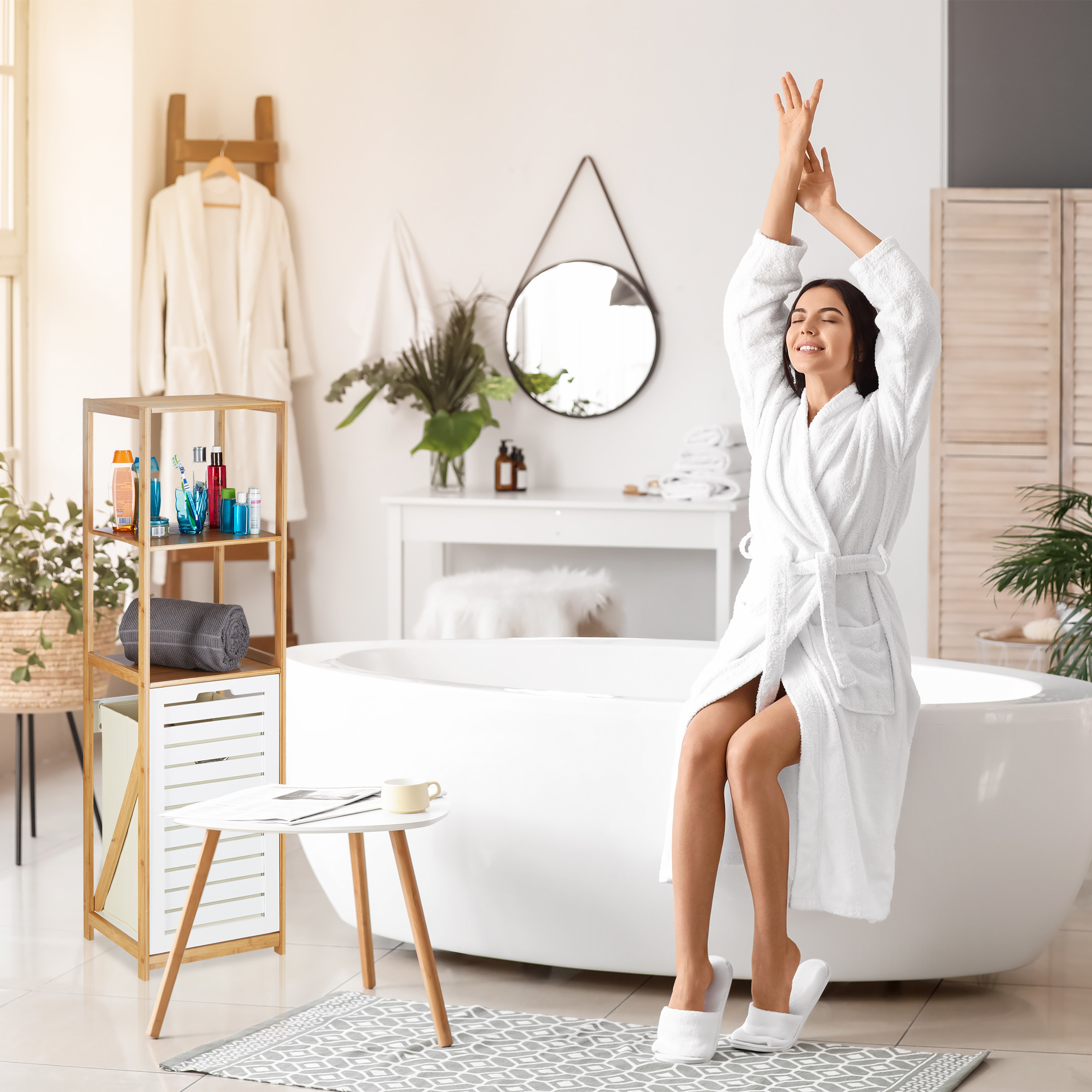 Eine glückliche Frau im weißen Bademantel streckt sich morgens im modernen Badezimmer.