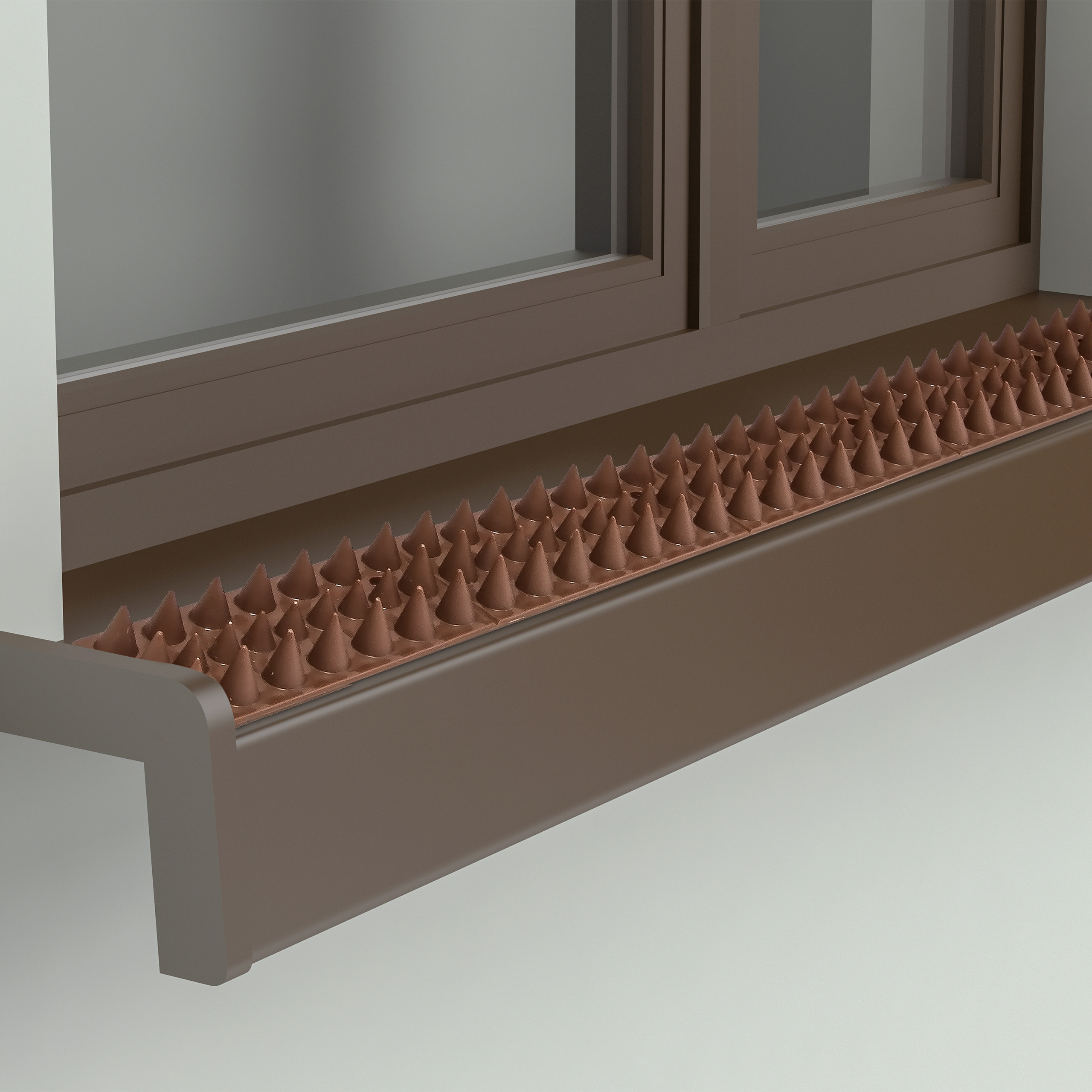 Braune Taubenabwehrspitzen auf einer Fensterbank unter einem braunen Fenster.