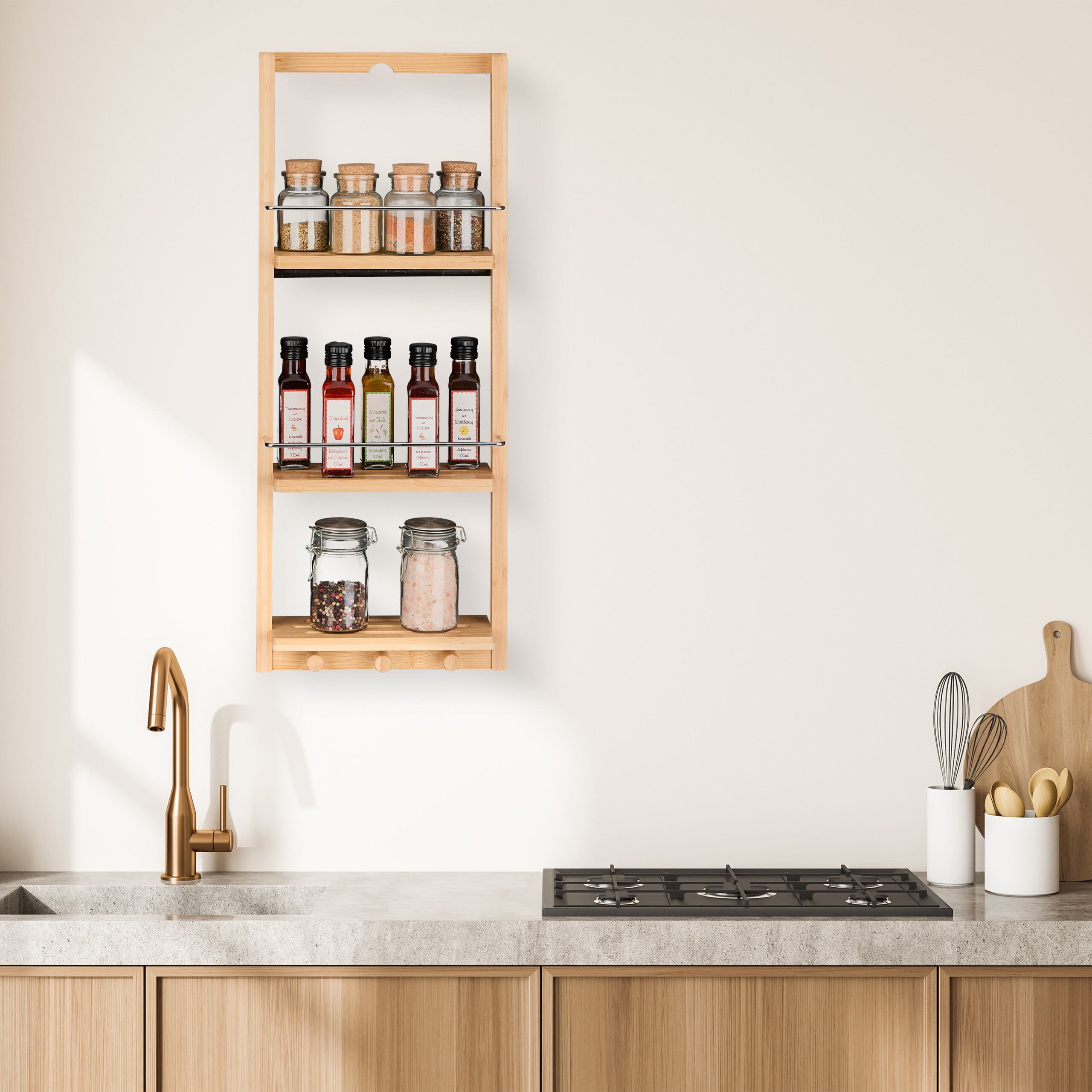 Ein Gewürzregal aus Holz an einer weißen Wand über einer Küchenzeile mit Spüle und Kochfeld.