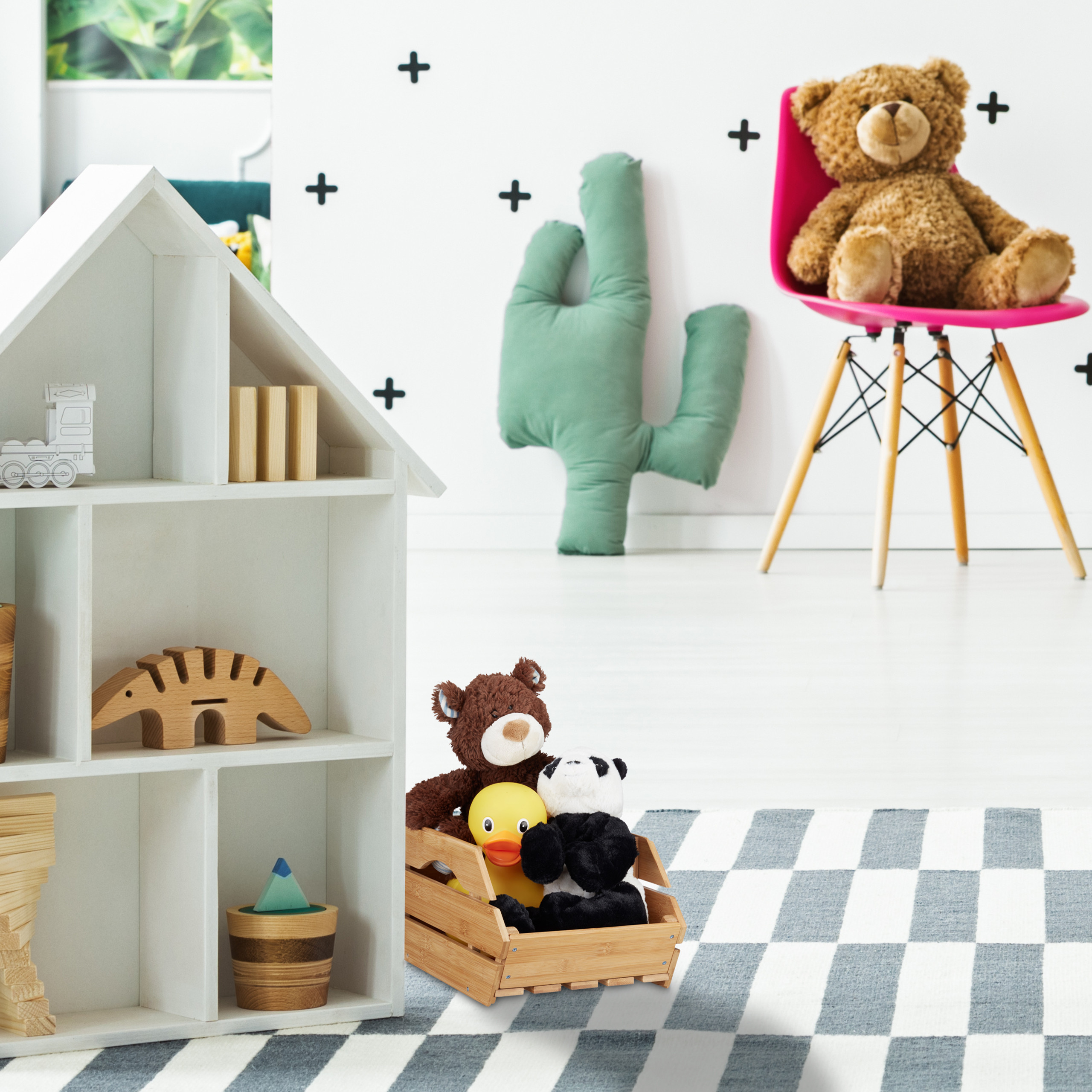 Ein weißes Puppenhaus im Vordergrund und ein Plüschbär auf einem pinken Stuhl im Hintergrund eines kindlichen Zimmers.