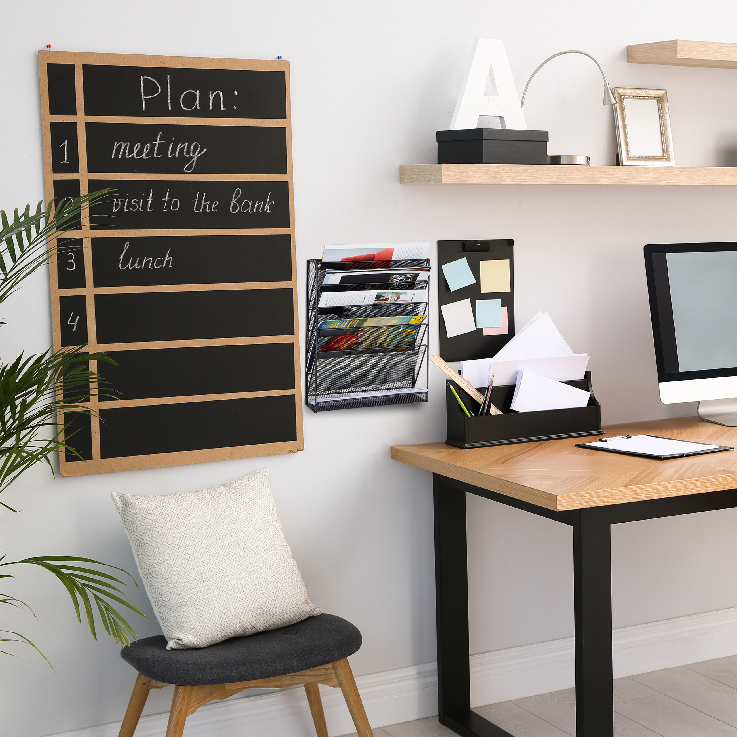Ein ordentliches Büro mit Schreibtisch, Wandplaner, Stuhl und Regalen mit Dekoration.