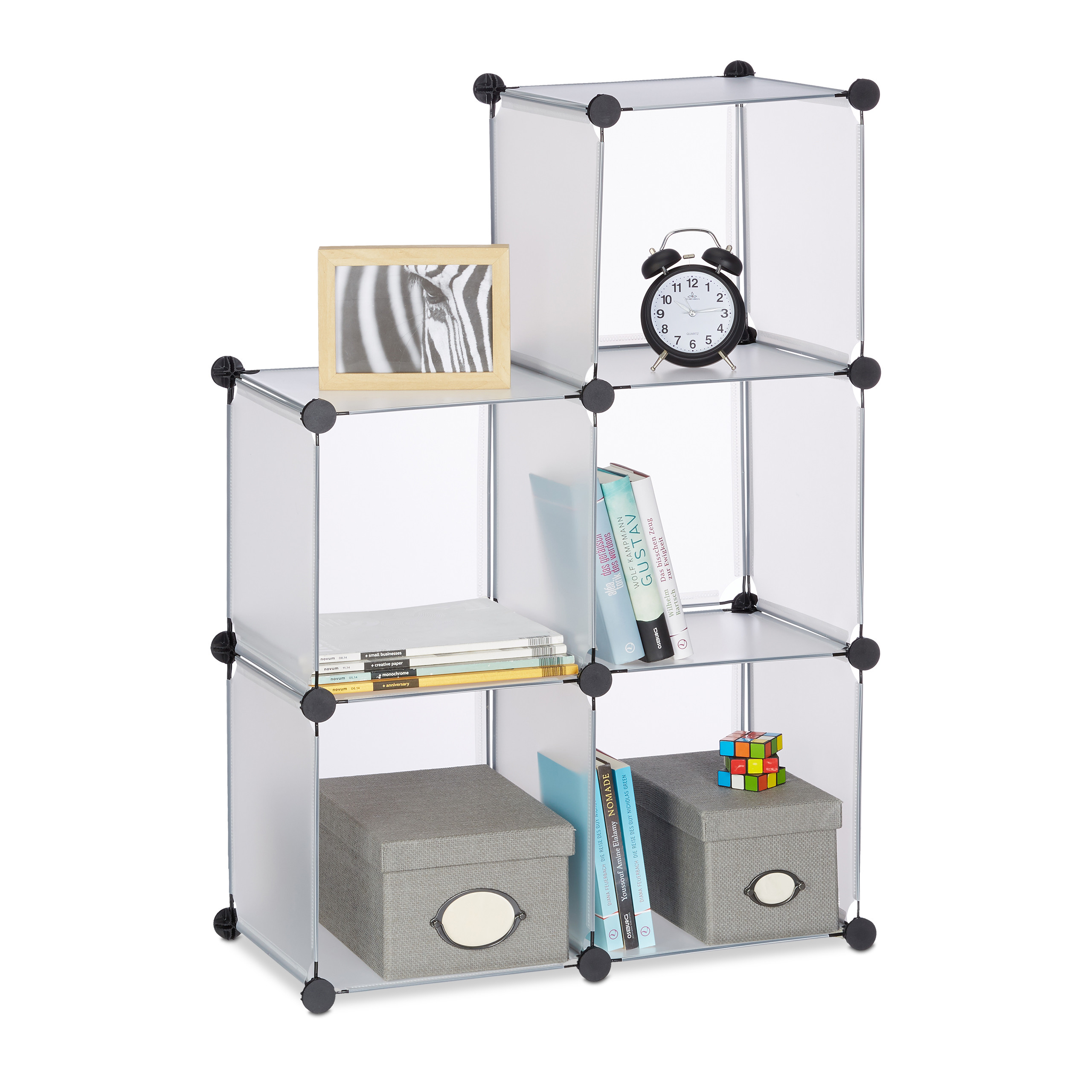 Modulares weißes Regal mit sechs Fächern, dekoriert mit Büchern, Uhren, Schachteln und einem Fotorahmen.