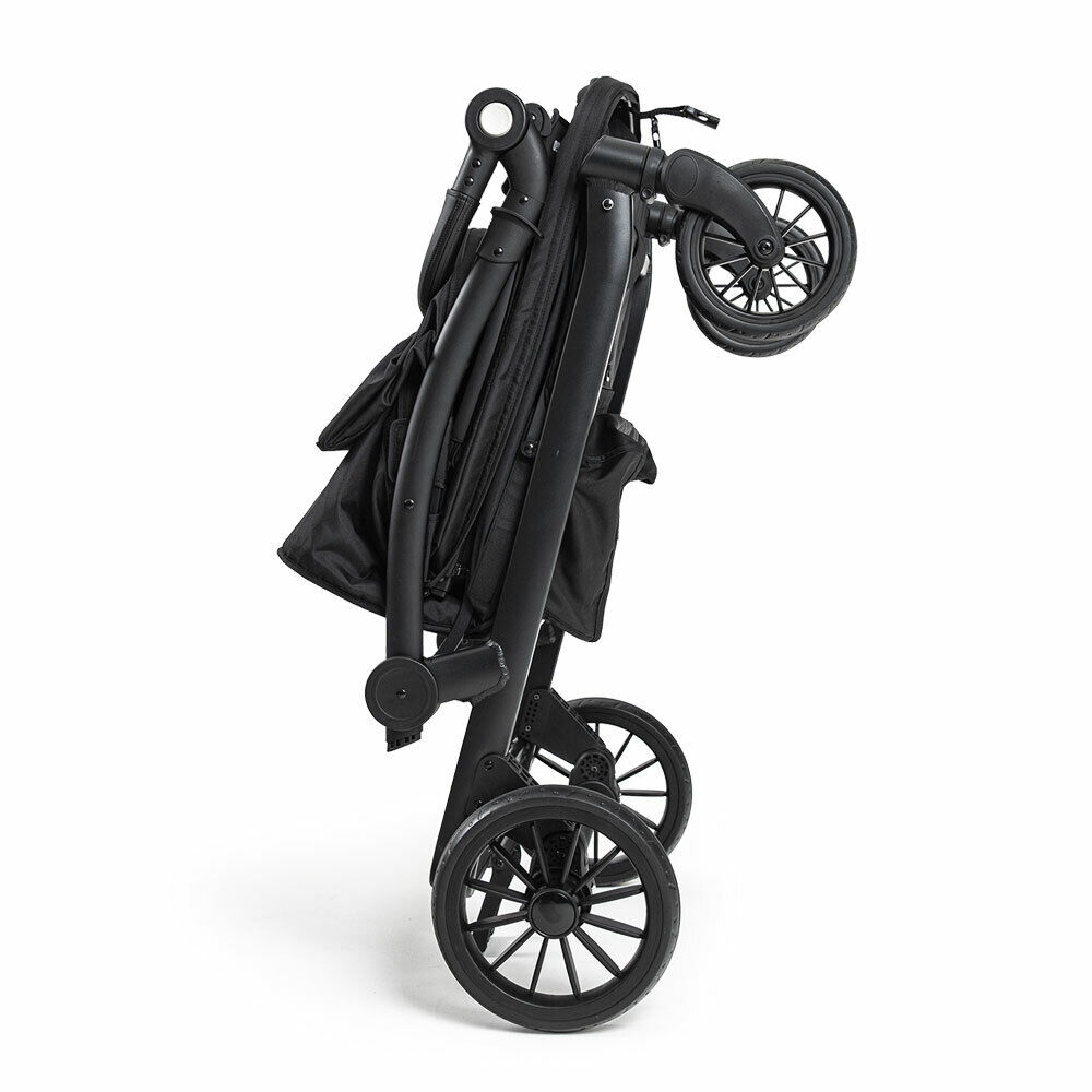 Ein zusammengeklappter schwarzer Kinderwagen steht aufrecht vor weißem Hintergrund.