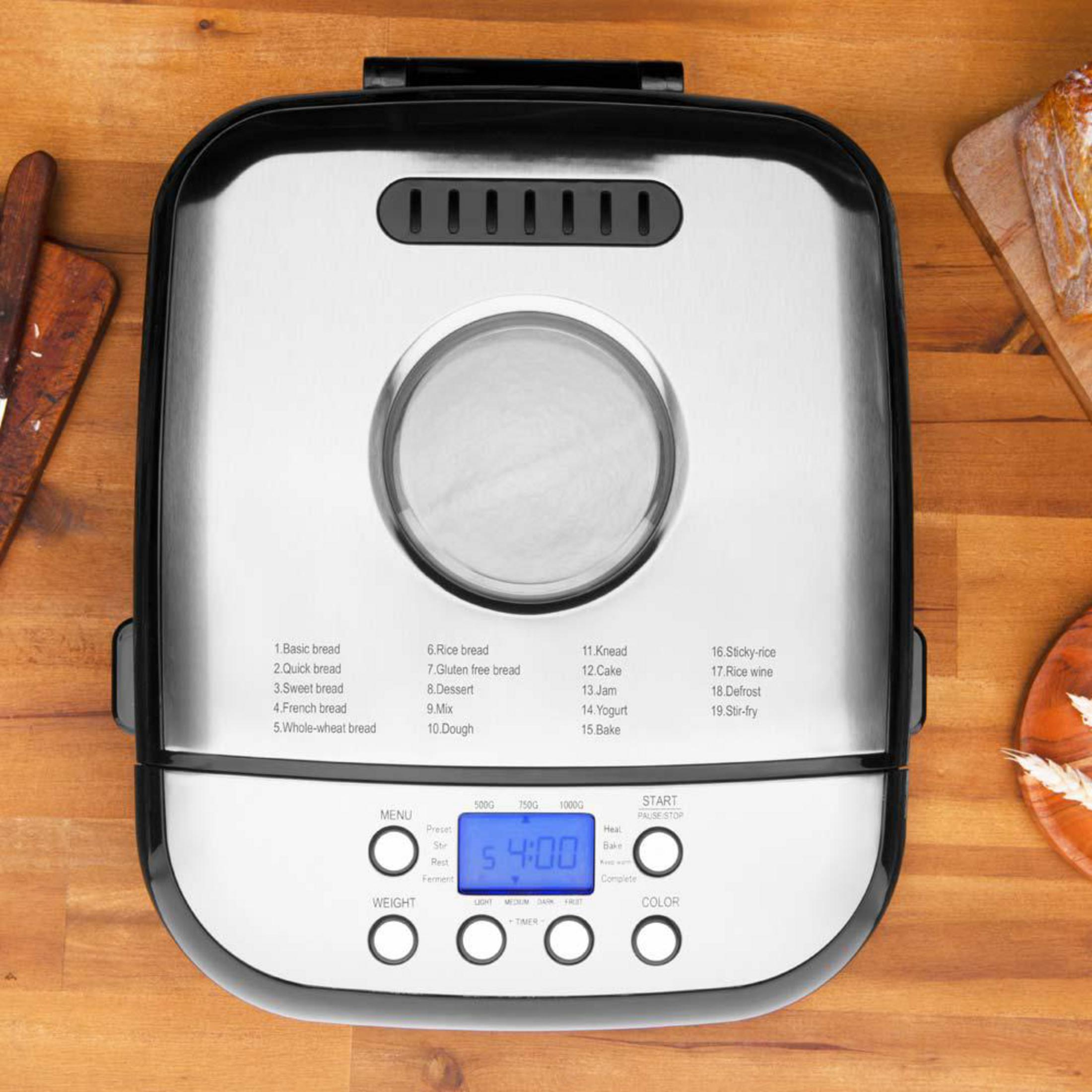 Draufsicht eines silbernen Brotbackautomaten auf einem Holztisch mit Display, Tasten und Menüliste.