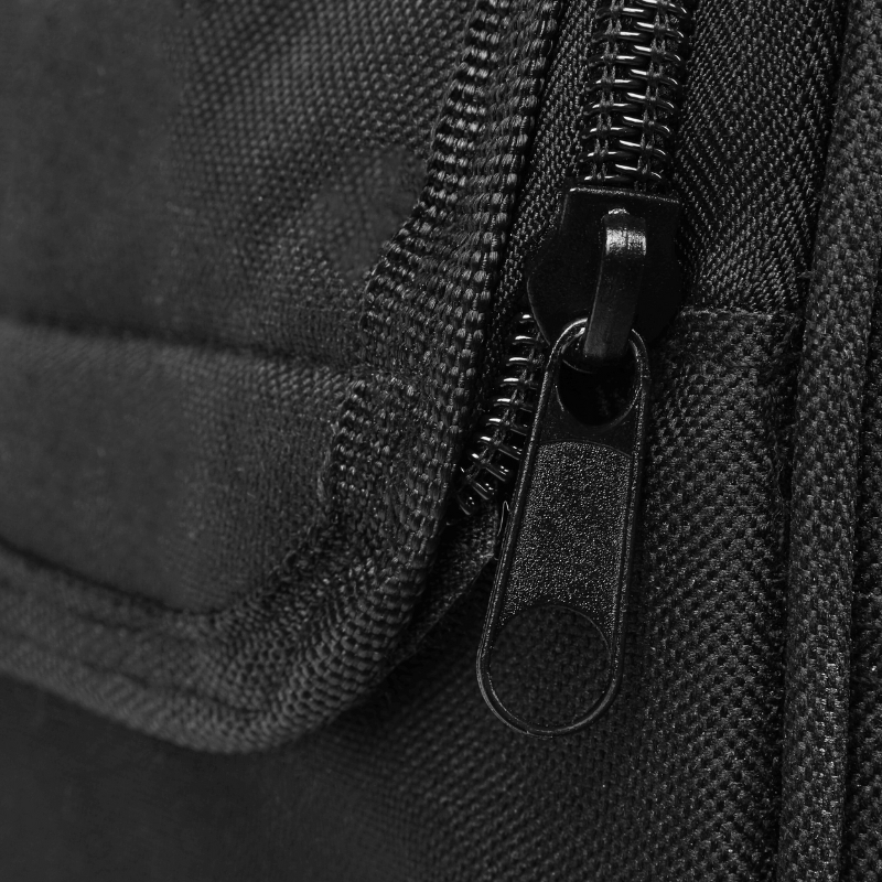 Nahaufnahme einer schwarzen Stofftasche mit Reißverschluss und Zipper vor strukturiertem Hintergrund.