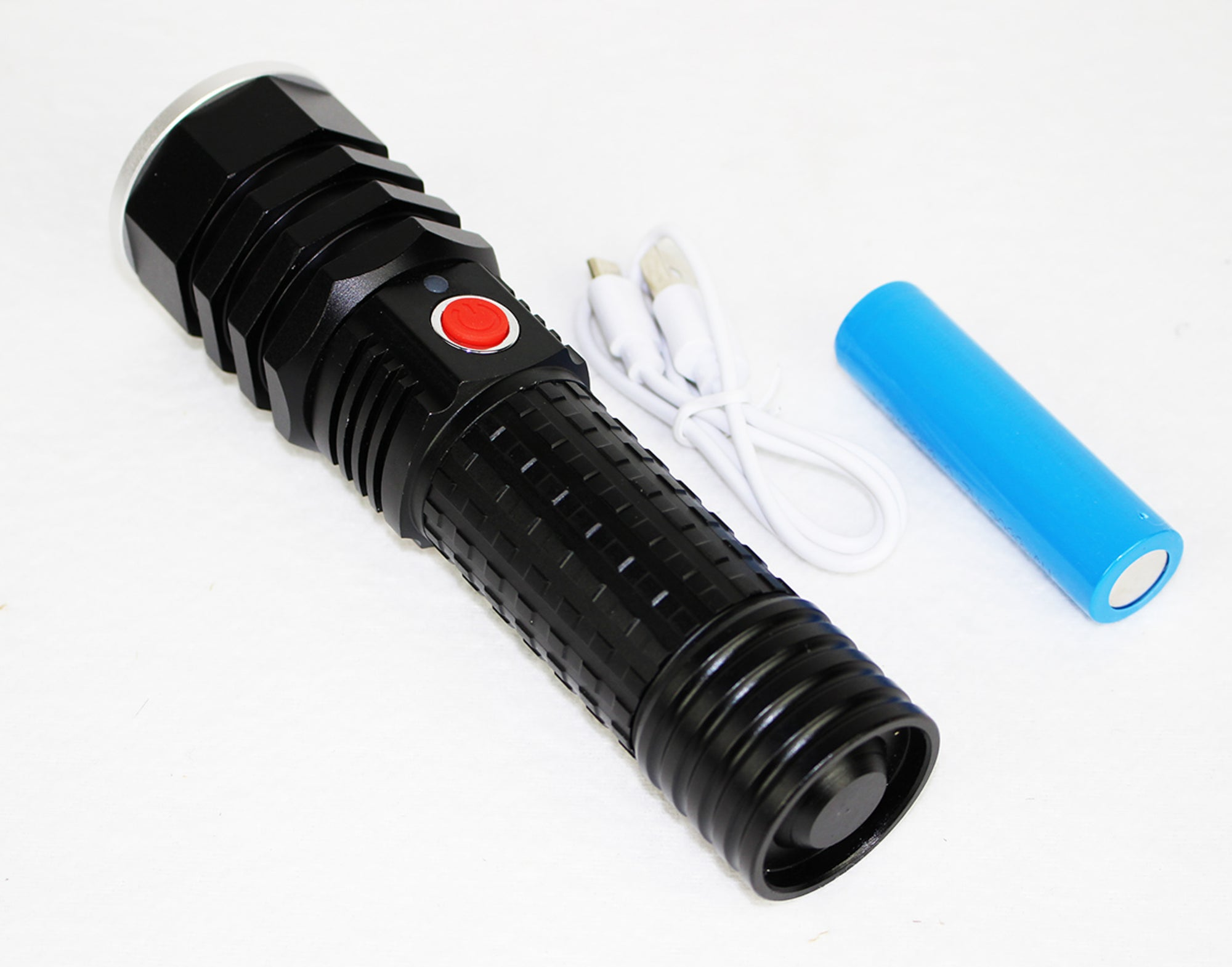Eine schwarze Taschenlampe mit rotem Knopf, ein weißes Ladekabel und eine blaue Batterie auf weißem Grund.