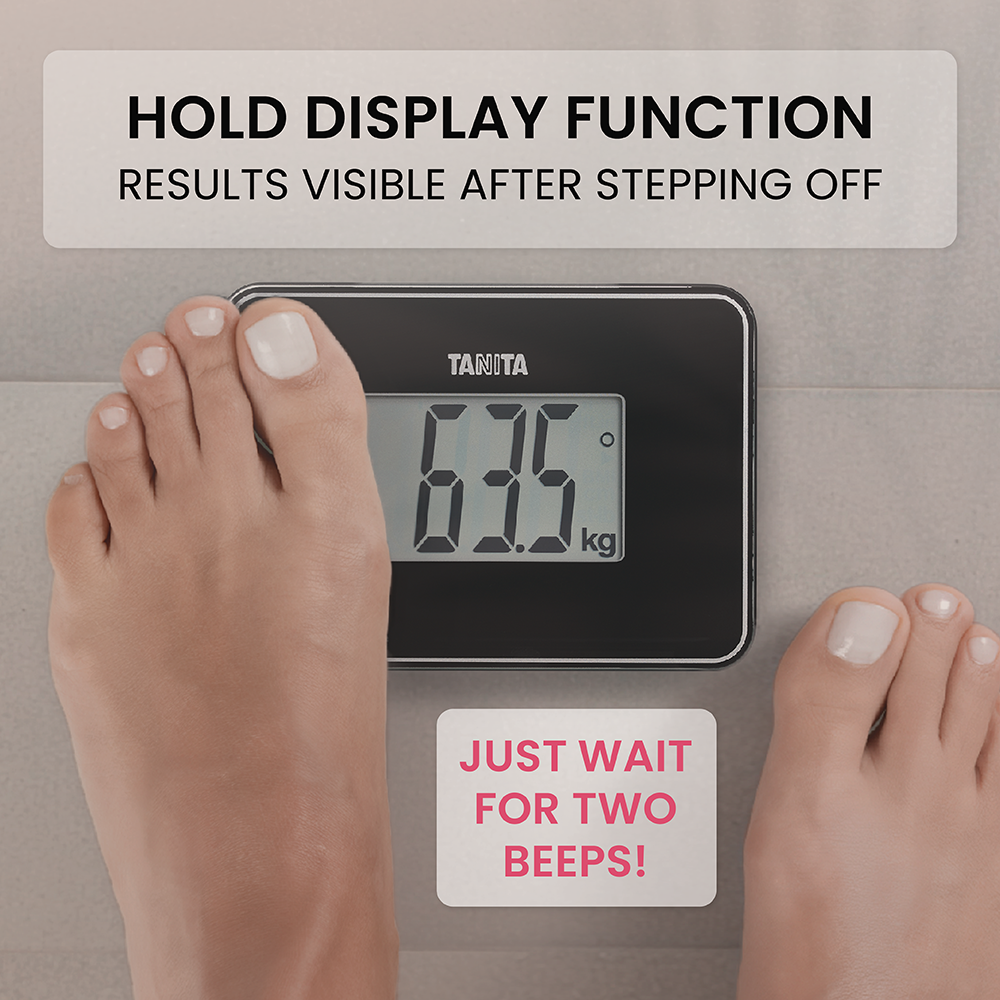 Feet on a Tanita scale showing 63.5 kg with hold function text.