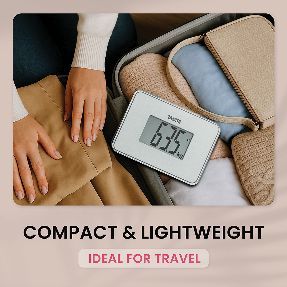Compact digital scale resting inside an open suitcase among clothes and a bag.