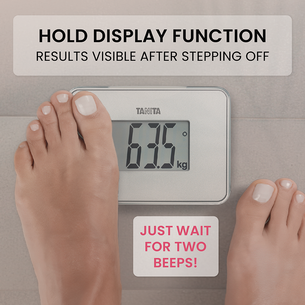 Feet standing on a Tanita scale showing 63.5 kg with hold function text.